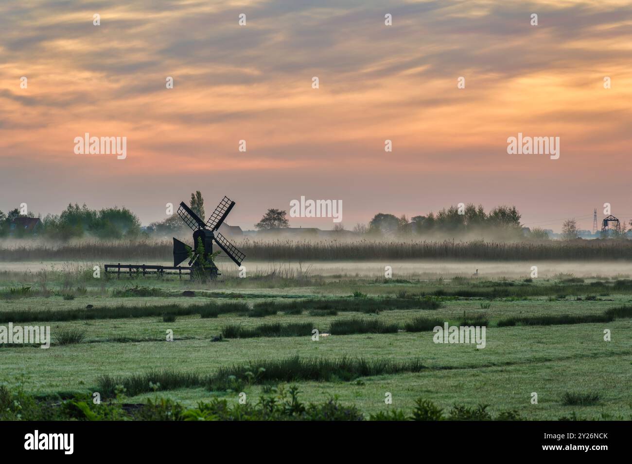 Kleine niederländische Windmühle und Sonnenaufgang im Dorf Zaanse Schans, Amsterdam Niederlande Stockfoto