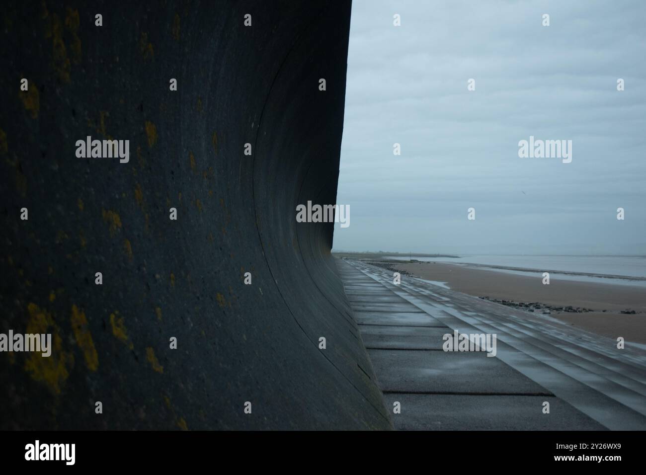 Wellenbruch bei Ebbe bei schwachem Licht Stockfoto