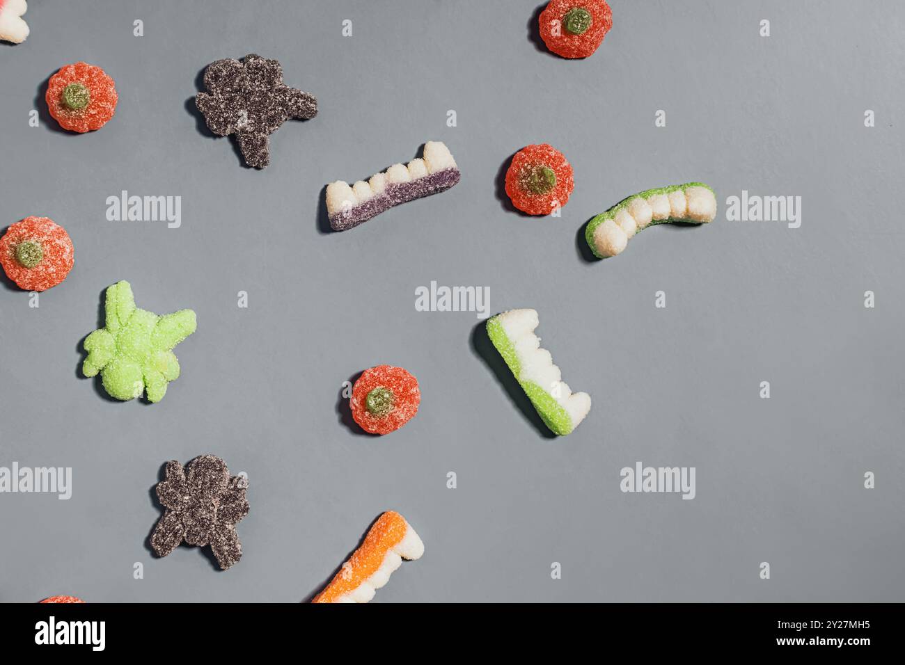 Bunte Auswahl an gummiartigen Halloween-Bonbons auf grauem Hintergrund Stockfoto