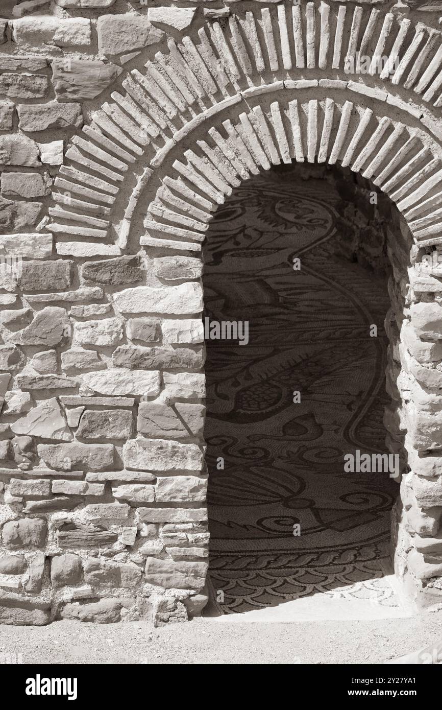 Arch Frame Mosaic in Shadows: Licht und Schatten auf einem Steinmauerhintergrund. Stockfoto