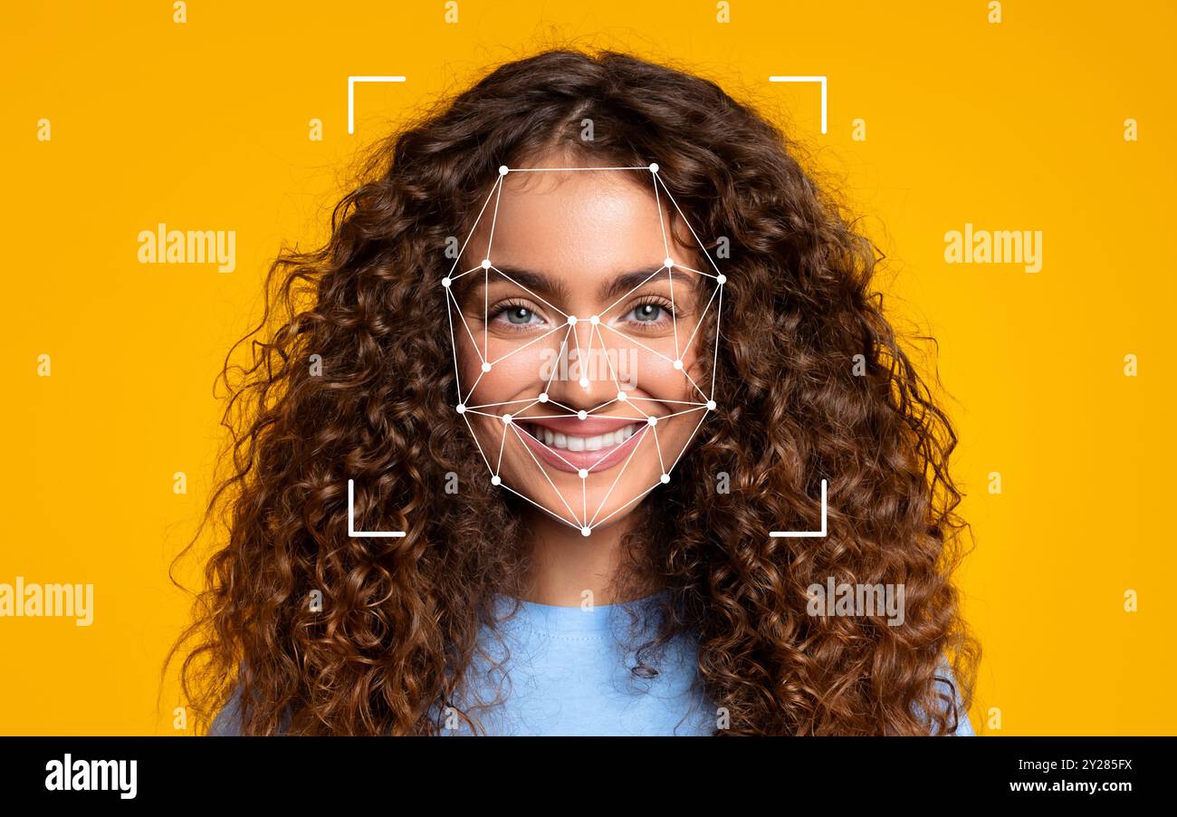 Lockige Frau lächelt mit einer Gesichtserkennung Stockfoto