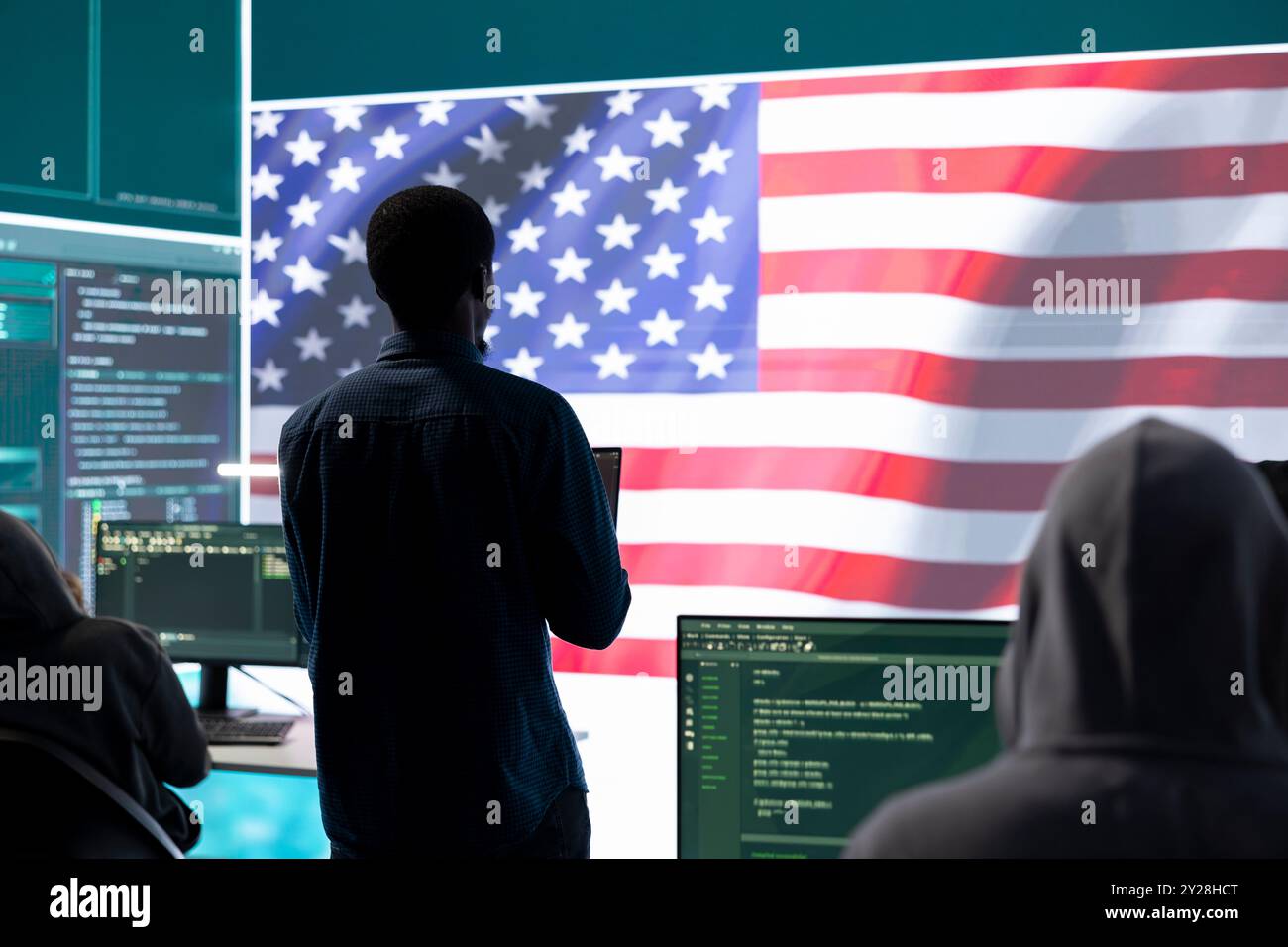 Ein technisches Team in einer staatlichen Cyberumgebung mit der US-Flagge. Konzentrieren Sie sich auf Cybersicherheitsstrategie, Bedrohungsmanagement und sichere Abläufe für nationale Sicherheit und digitale Verteidigung. Stockfoto