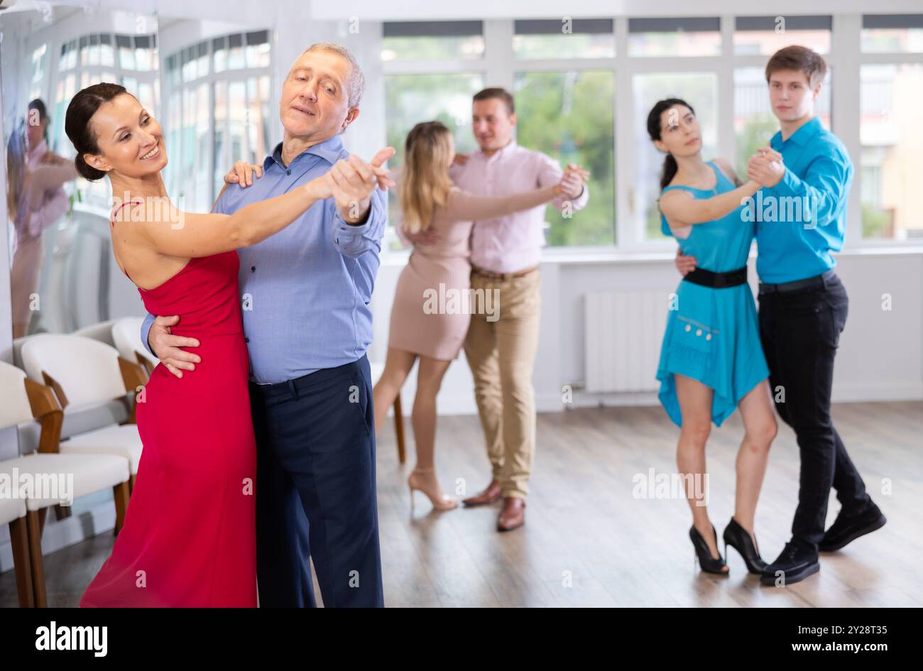 Ein älterer Mann genießt langsamen Foxtrott mit einer Partnerin im Tanzstudio Stockfoto