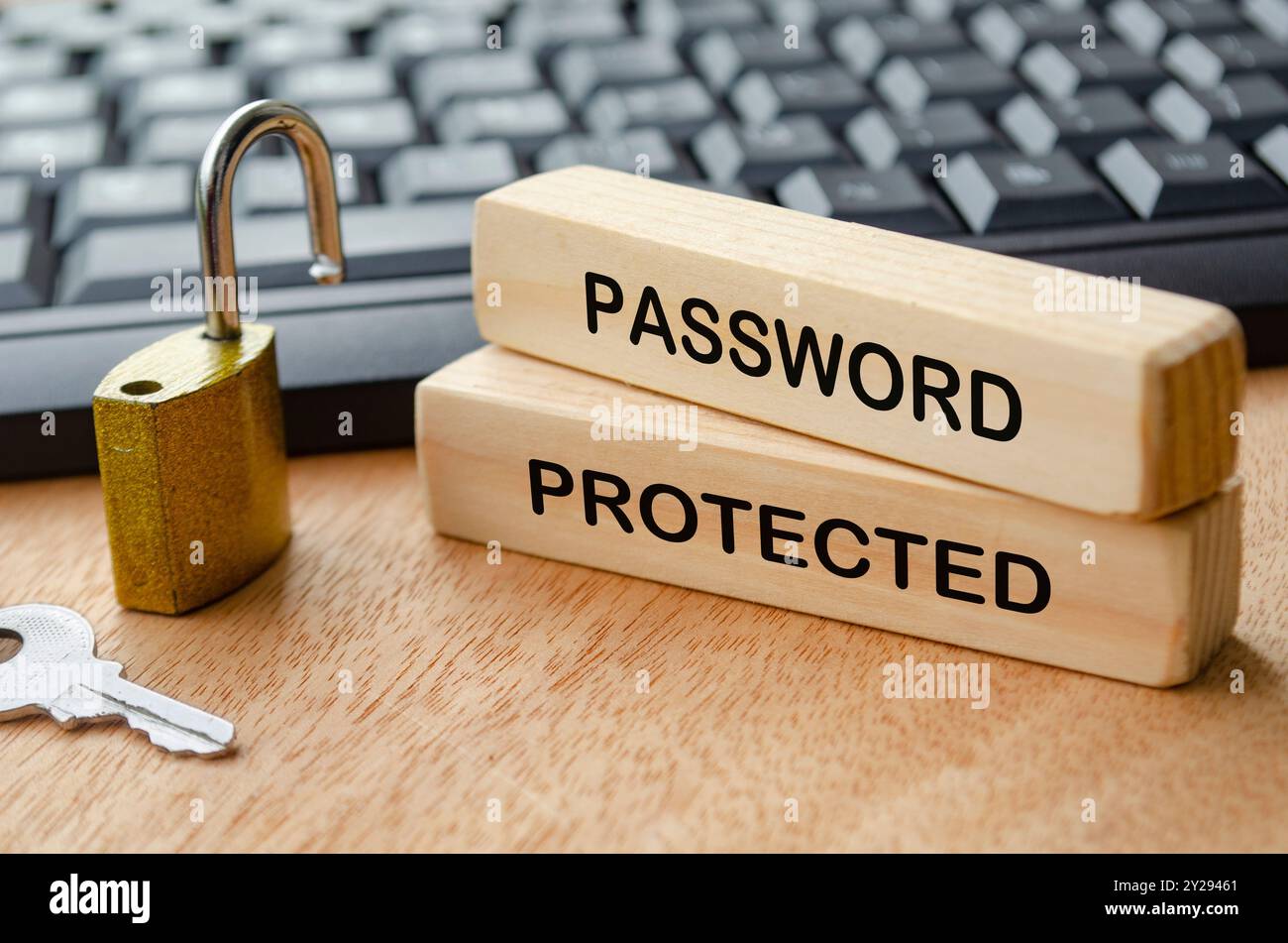 Passwortgeschützter Text auf Holzblöcken mit Vorhängeschloss und Laptop-Tastatur Hintergrund. Sicherheitskonzept für Kennwörter. Stockfoto
