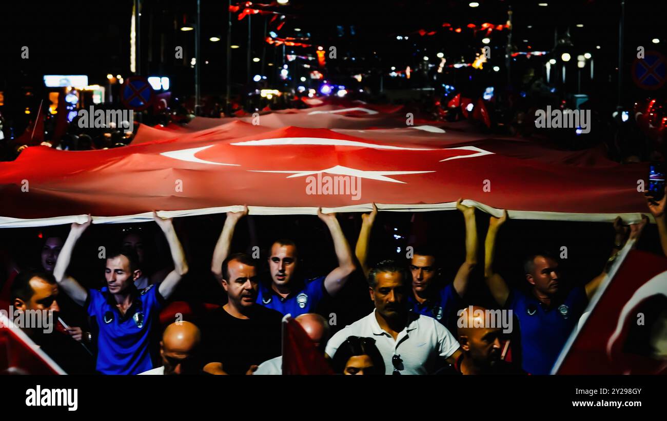 Izmir, Türkei. September 2024. Der Jahrestag der Befreiung von Izmir am 9. September, ein wichtiges Datum im türkischen Unabhängigkeitskrieg. Bei der Veranstaltung, bei der der 102. Jahrestag der Befreiung Izmirs von der feindlichen Besatzung gefeiert wurde, wurde eine 350 Meter hohe türkische Flagge von den Menschen getragen, die an der Fackelprozession teilnahmen. Quelle: İdil Toffolo/Alamy Live News Stockfoto
