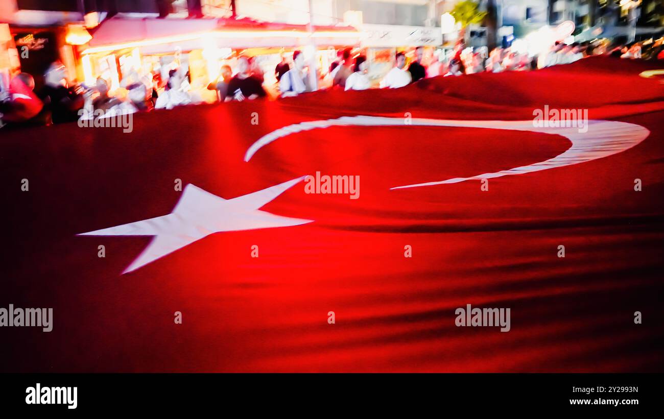 Izmir, Türkei. September 2024. Der Jahrestag der Befreiung von Izmir am 9. September, ein wichtiges Datum im türkischen Unabhängigkeitskrieg. Bei der Veranstaltung, bei der der 102. Jahrestag der Befreiung Izmirs von der feindlichen Besatzung gefeiert wurde, wurde eine 350 Meter hohe türkische Flagge von den Menschen getragen, die an der Fackelprozession teilnahmen. Quelle: İdil Toffolo/Alamy Live News Stockfoto
