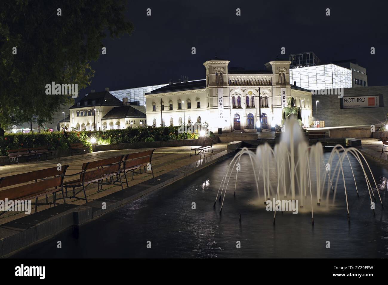 Historisches Gebäude bei Nacht mit beleuchtetem Brunnen und Bänken im Vordergrund, alter Ostbahnhof, Friedensnobelpreisträger Stockfoto