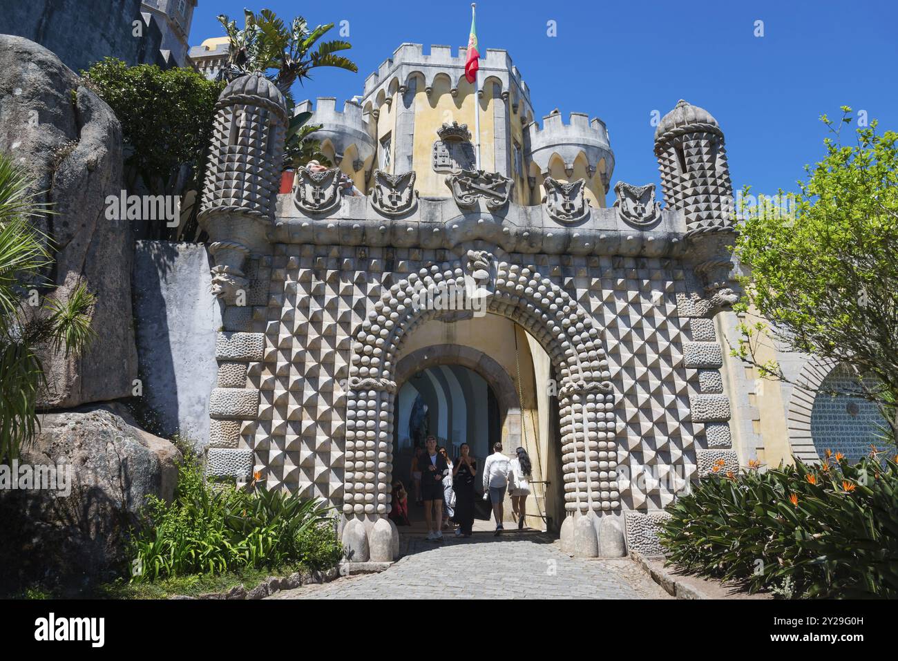 Eingangstor zu einer Burg mit dekorativen Steinmustern und Pflanzen, Besucher sind sichtbar, Palacio Nacional da Pena, Nationalpalast Pena, Sintra, Lis Stockfoto