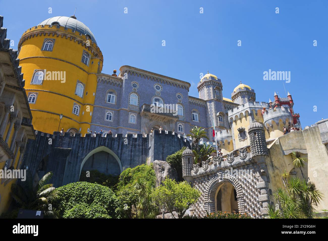 Schloss mit grauen und gelben Türmen vor einem blauen Himmel, umgeben von Pflanzen, Palacio Nacional da Pena, Pena National Palace, Sintra, Lissabon, World her Stockfoto