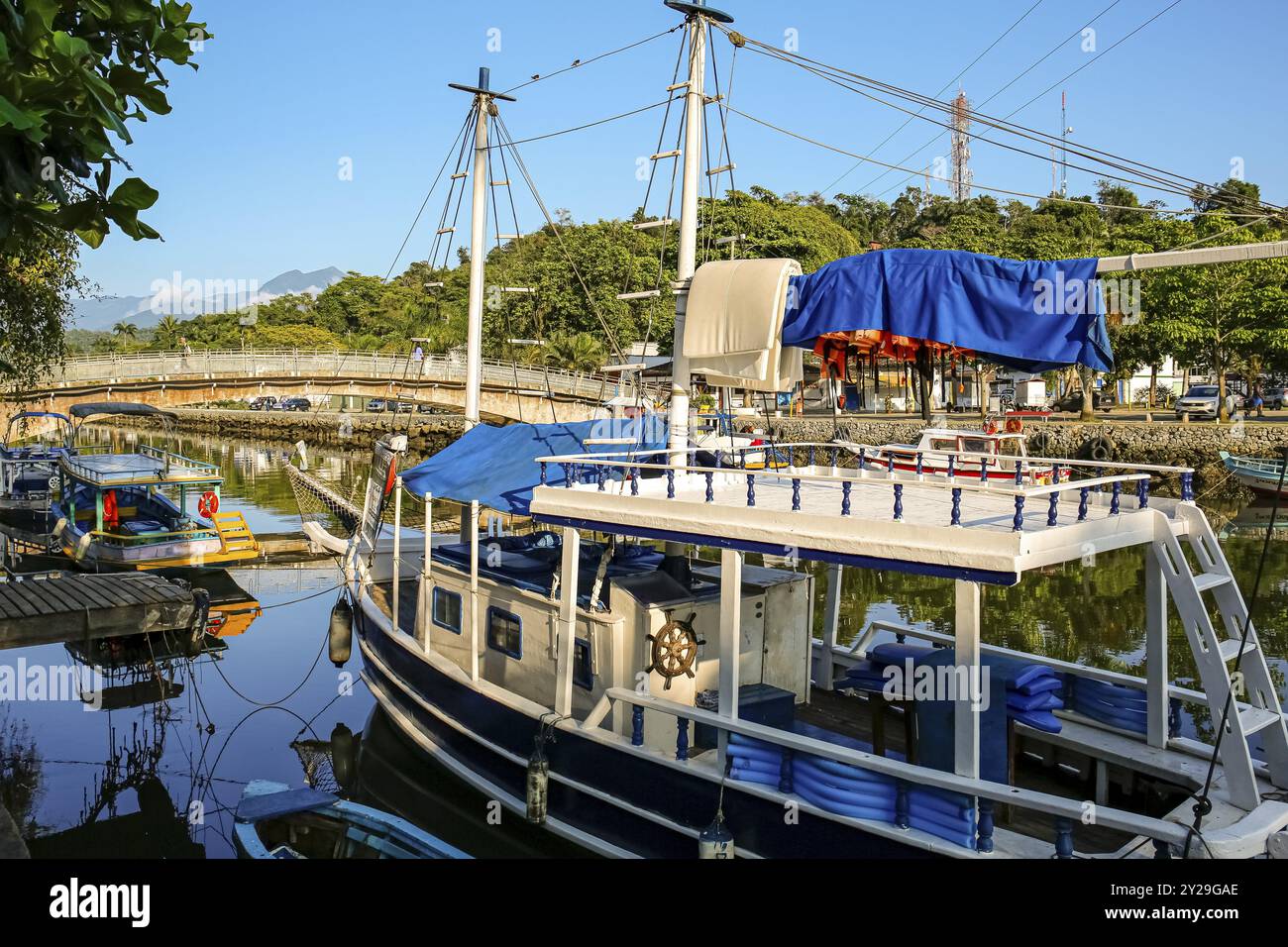 Touristenboot auf dem Fluss Pereqe-ACU mit großem im Hintergrund an einem sonnigen Tag in der UNESCO-Weltkulturerbestätte Paraty, Brasilien, Südamerika Stockfoto