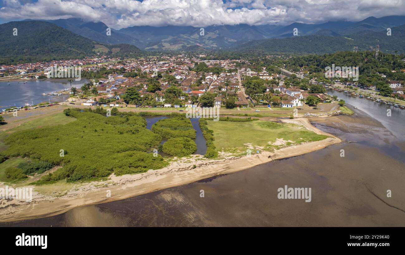 Blick aus der Vogelperspektive auf die historische Stadt Paraty mit Gezeitenfluss und grünen Bergen im Hintergrund, sonnigen Himmel mit weißen Wolken, Brasilien, UNESCO-Weltkulturerbe, so Stockfoto