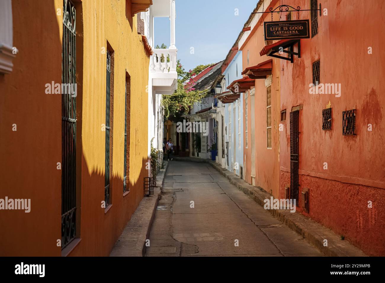 Enge Straße in der Altstadt von Cartagena mit farbenfrohen einstöckigen Häusern in Sonnenlicht und Schatten, Kolumbien, Südamerika Stockfoto