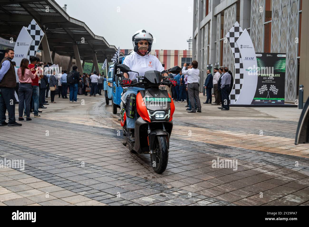 Neu-Delhi, Indien. September 2024. Eine weibliche Fahrerin fährt einen Elektroroller während der 2. Auflage der SIAM Green Plate EV Rally, die am World Electric Vehicle Day in Neu-Delhi stattfand. SIAM organisierte die EV-Rallye in Anwesenheit von H.D. Kumaraswamy, Gewerkschaftsminister für Schwerindustrie der indischen Regierung. Die Rallye zielte auf die Förderung von Elektrofahrzeugen ab, an denen insgesamt 251 Fahrzeuge teilnahmen. Quelle: SOPA Images Limited/Alamy Live News Stockfoto