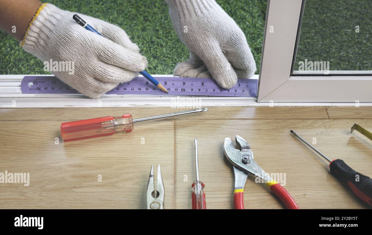 Bauarbeiter, der das Schiebefenster repariert. Stockfoto