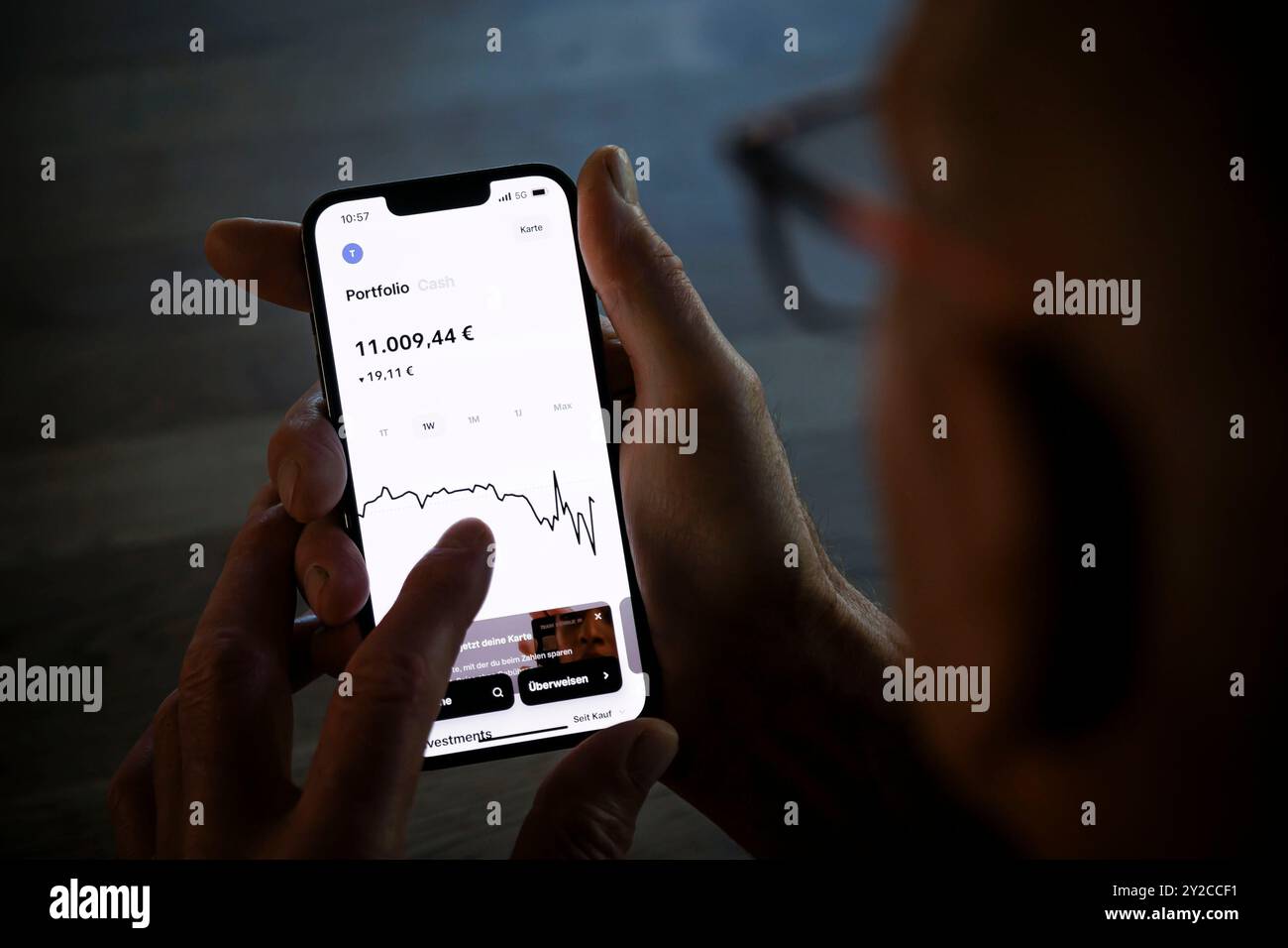 Symbolfoto zum Thema digitale Abwicklung von Finanztransaktionen im Alter. Ein alter Mann hält ein Smartphone mit der Trade Republic App und überprüft den Aktienkurs seiner Investition. Berlin, 5. September 2024. Stockfoto