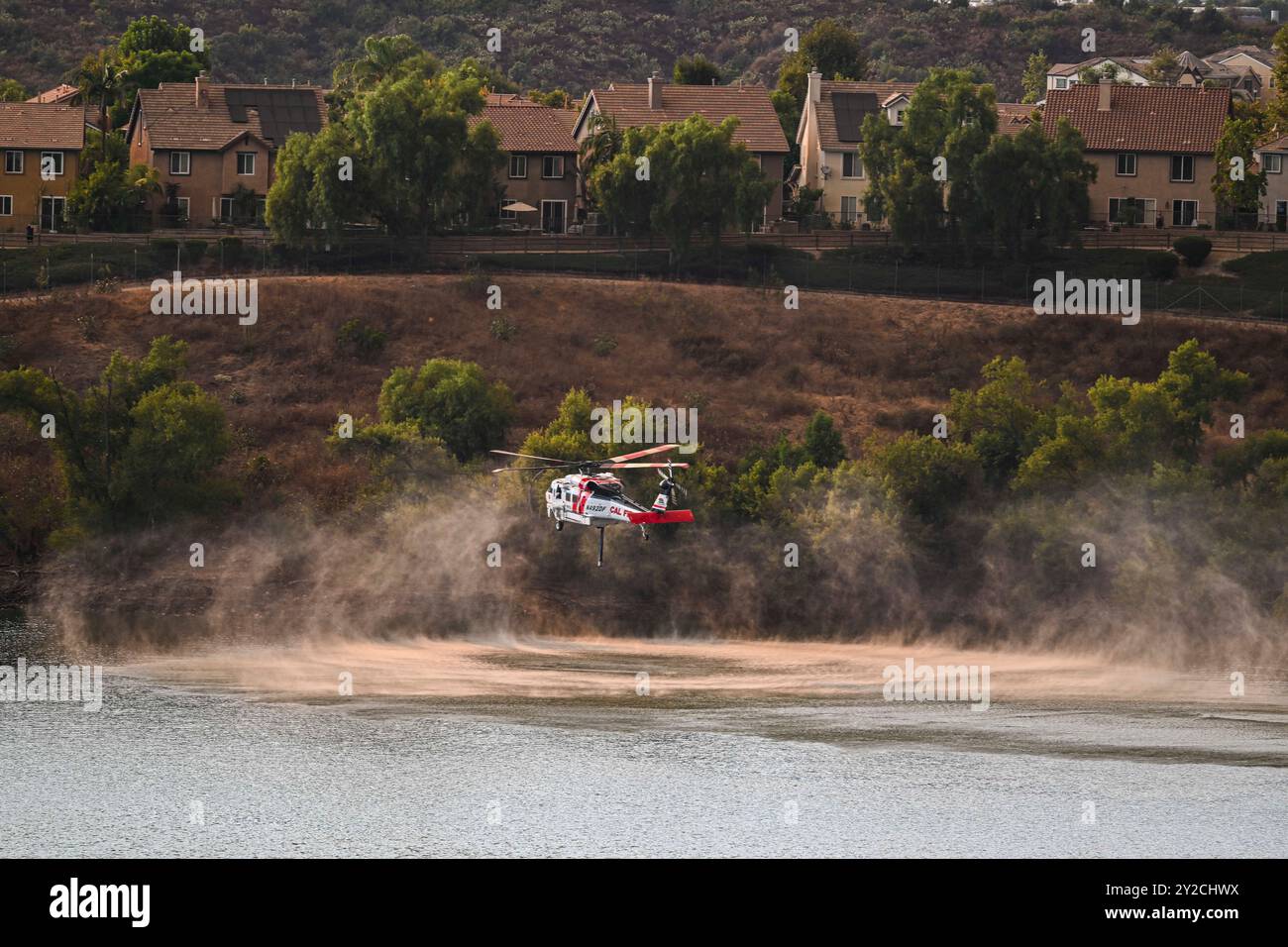 Rancho Santa Margarita, Usa. September 2024. Ein Kal-Feuer-Hubschrauber kommt zum Nachfüllen am örtlichen Reservoir. Das Flughafenfeuer im Trabuco Canyon im Orange County, Kalifornien, wächst auf über 5.000 Hektar und erzwingt Evakuierungswarnungen. Eine Ursache ist noch nicht bekannt. Quelle: SOPA Images Limited/Alamy Live News Stockfoto