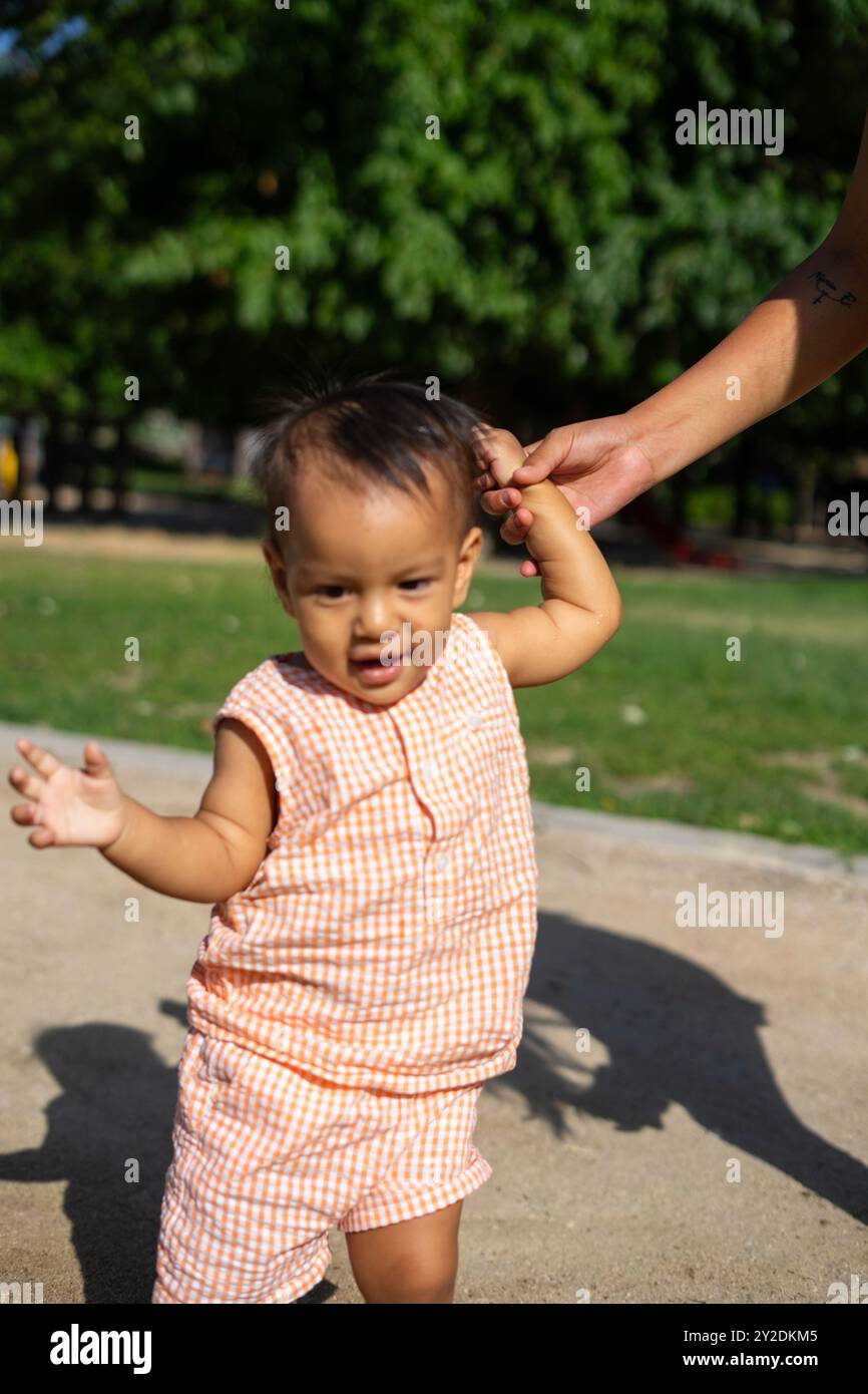 Die 1-jährige Latina macht ihre ersten Schritte in einem Park im Freien Stockfoto