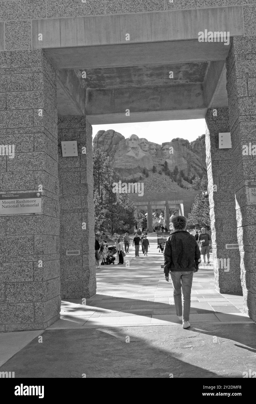 Kaukasische Frau (55 bis 60 Jahre), die den Eingang des Mount Rushmore National Memorial in South Dakota, USA, betritt. Stockfoto