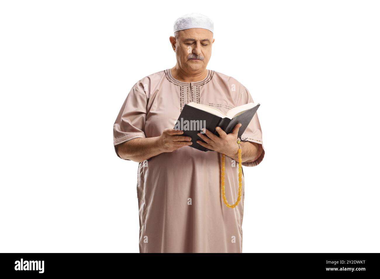 Muslimischer Mann in traditioneller Kleidung liest ein Buch isoliert auf weißem Hintergrund Stockfoto