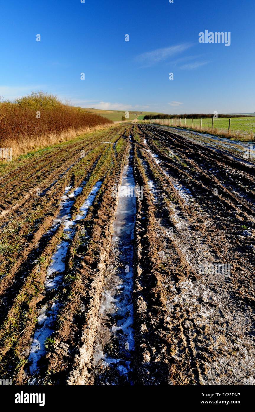 Gefrorene Spuren entlang einer öffentlichen Straße in den Wiltshire Downs. Stockfoto