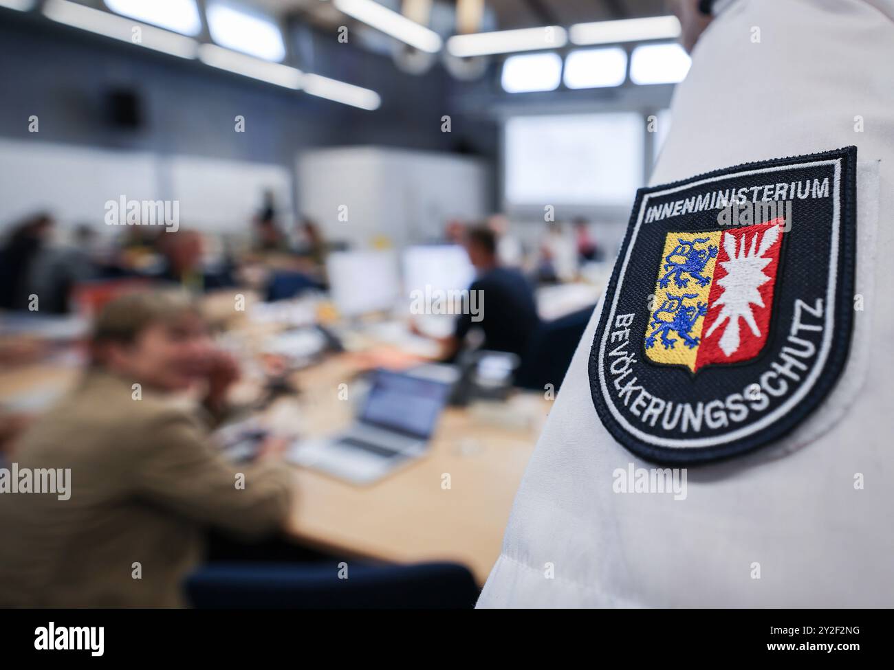 Kiel, Deutschland. September 2024. Ein Mitarbeiter der Abteilung Katastrophenschutz und Krisenmanagement des Innenministeriums steht während einer Pressekonferenz im Operationssaal während der Planungsübung für das Krisenteam zum Szenario „Sturmflut in der Ostsee“. Katastrophenhelfer bereiten sich auf den Einsatz im Falle einer schweren Sturmflut in der Ostsee vor wie im Oktober mit einer Planübung in Kiel bis Donnerstag. Quelle: Christian Charisius/dpa/Alamy Live News Stockfoto