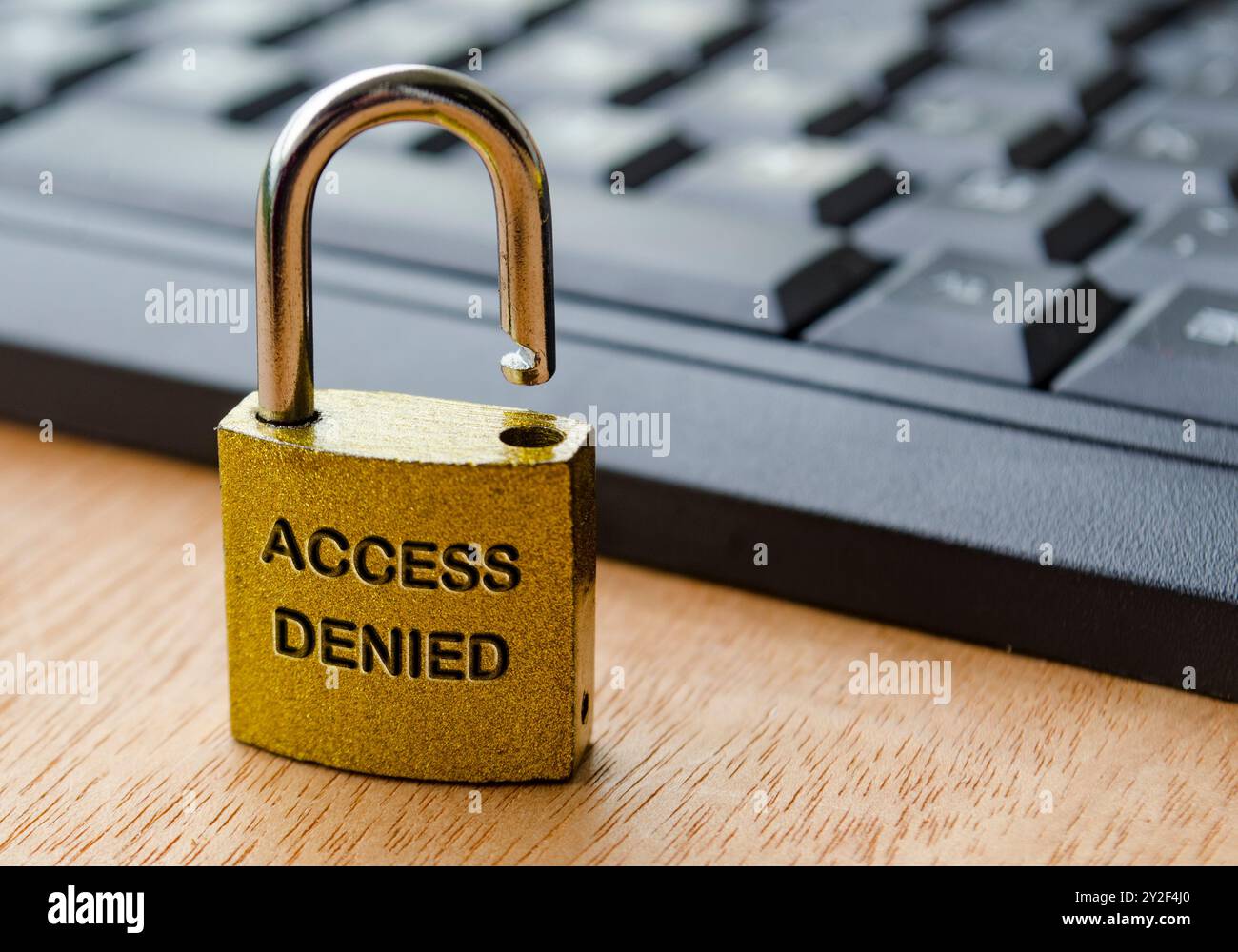 Zugriff verweigert Text auf Vorhängeschloss mit Tastaturhintergrund eingraviert. Passwort und Zugriffskonzept verwenden. Stockfoto