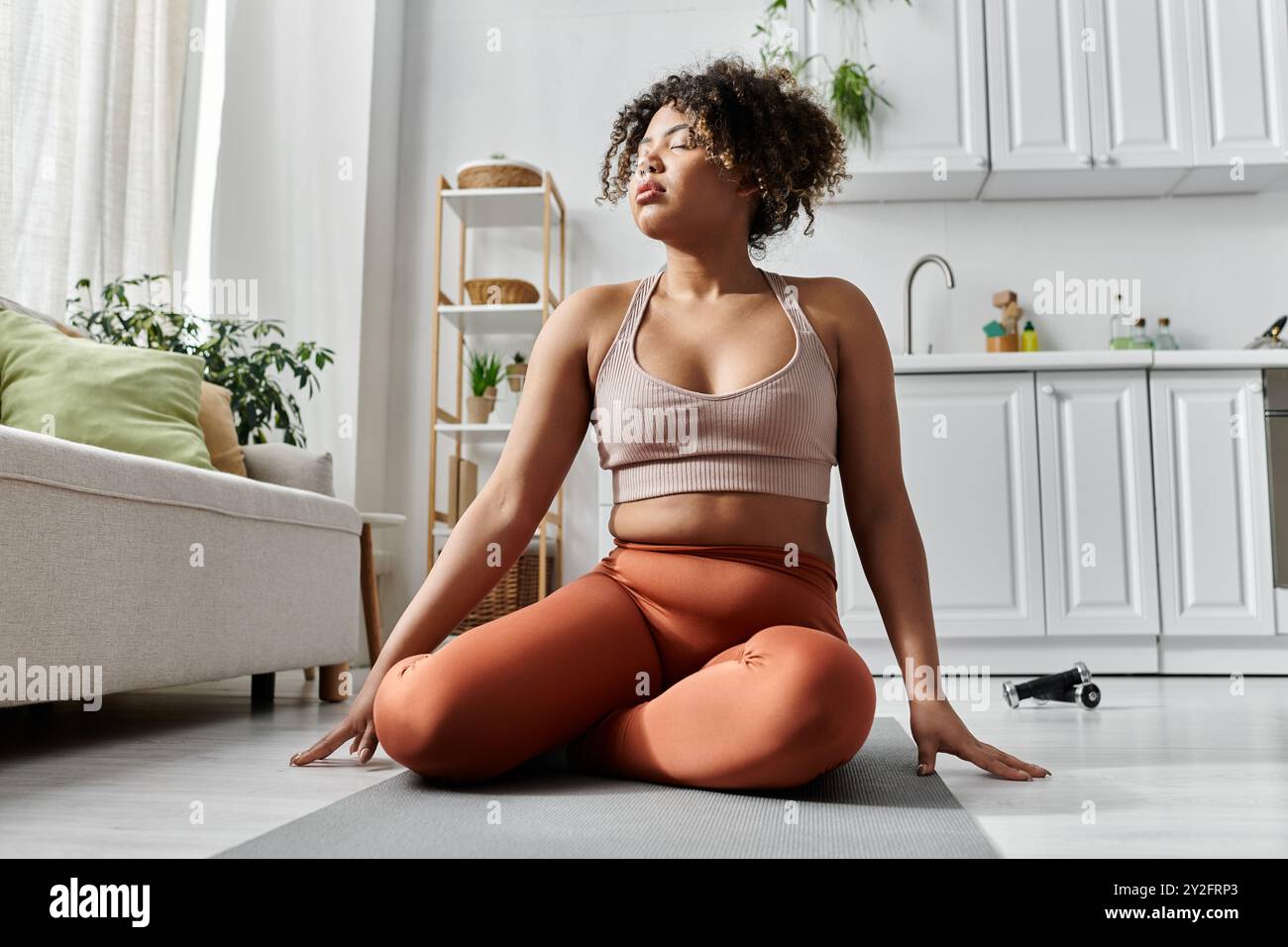 Eine junge Frau genießt eine friedliche Yoga-Session in ihrem einladenden Zuhause. Stockfoto