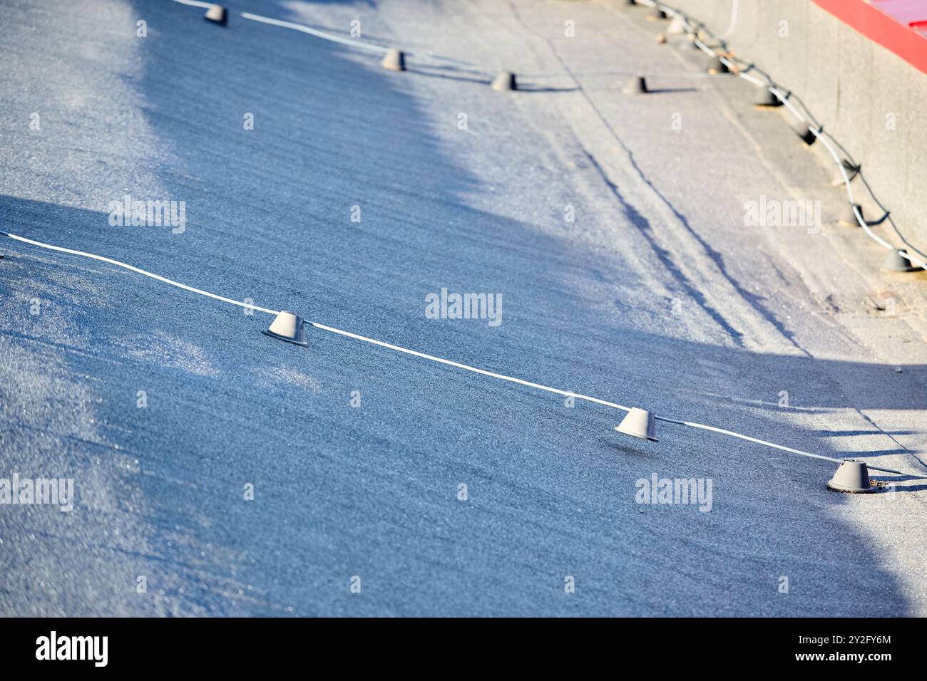 Blitzschutzsystem. Blitzschutzkomponenten Leiteranschlüsse Schrauben geerdet auf dem Dach eines gewerblichen Industriegebäudes. Stockfoto