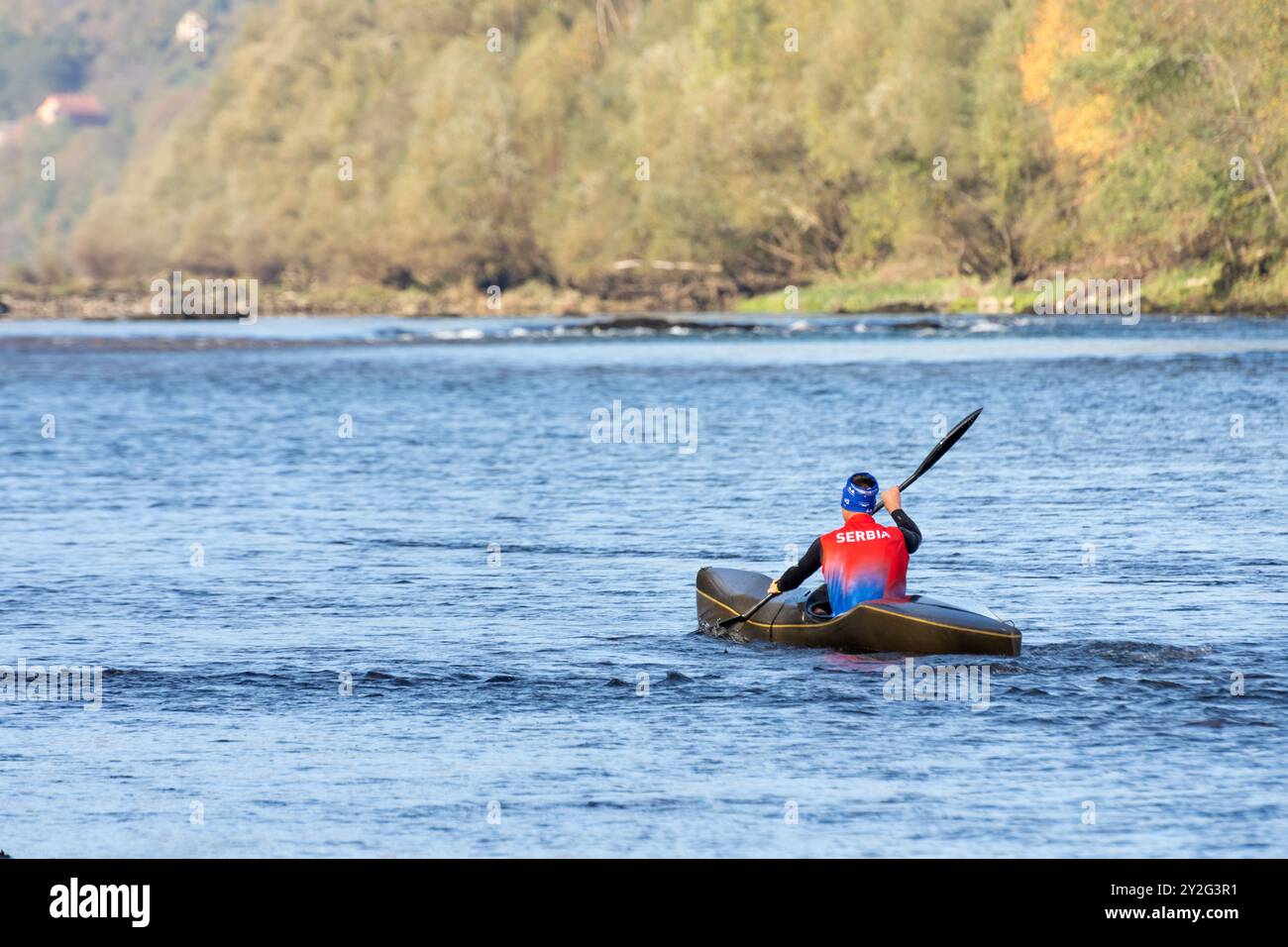 Bajina Basta, Serbien - 10. Oktober. 2023: Ein Mann in einem serbischen Trikot, der auf dem Drina-Fluss Kajak fährt. Stockfoto