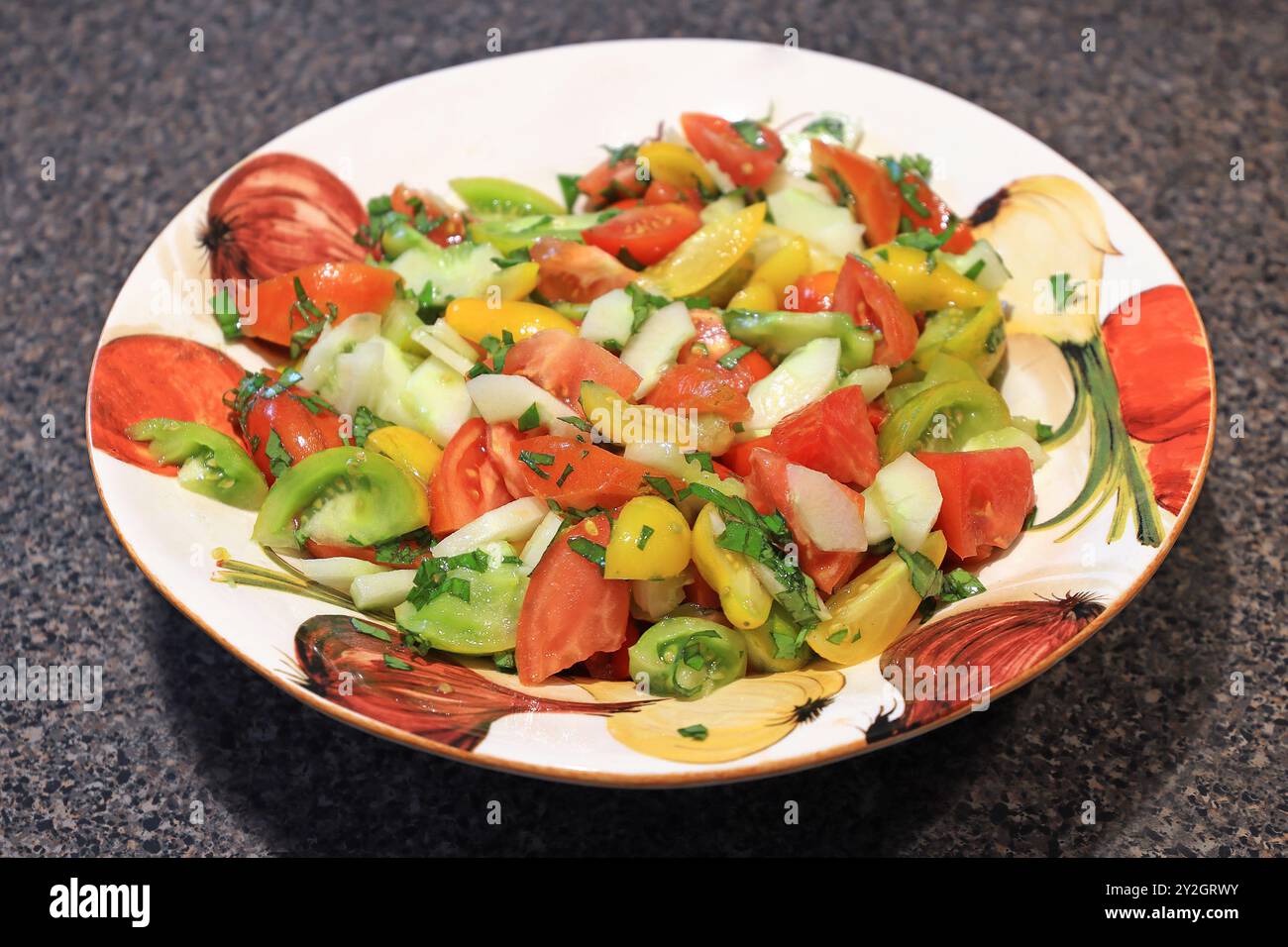 Tomatensalat mit Zucchini und Petersilie auf einem dekorierten Teller Stockfoto
