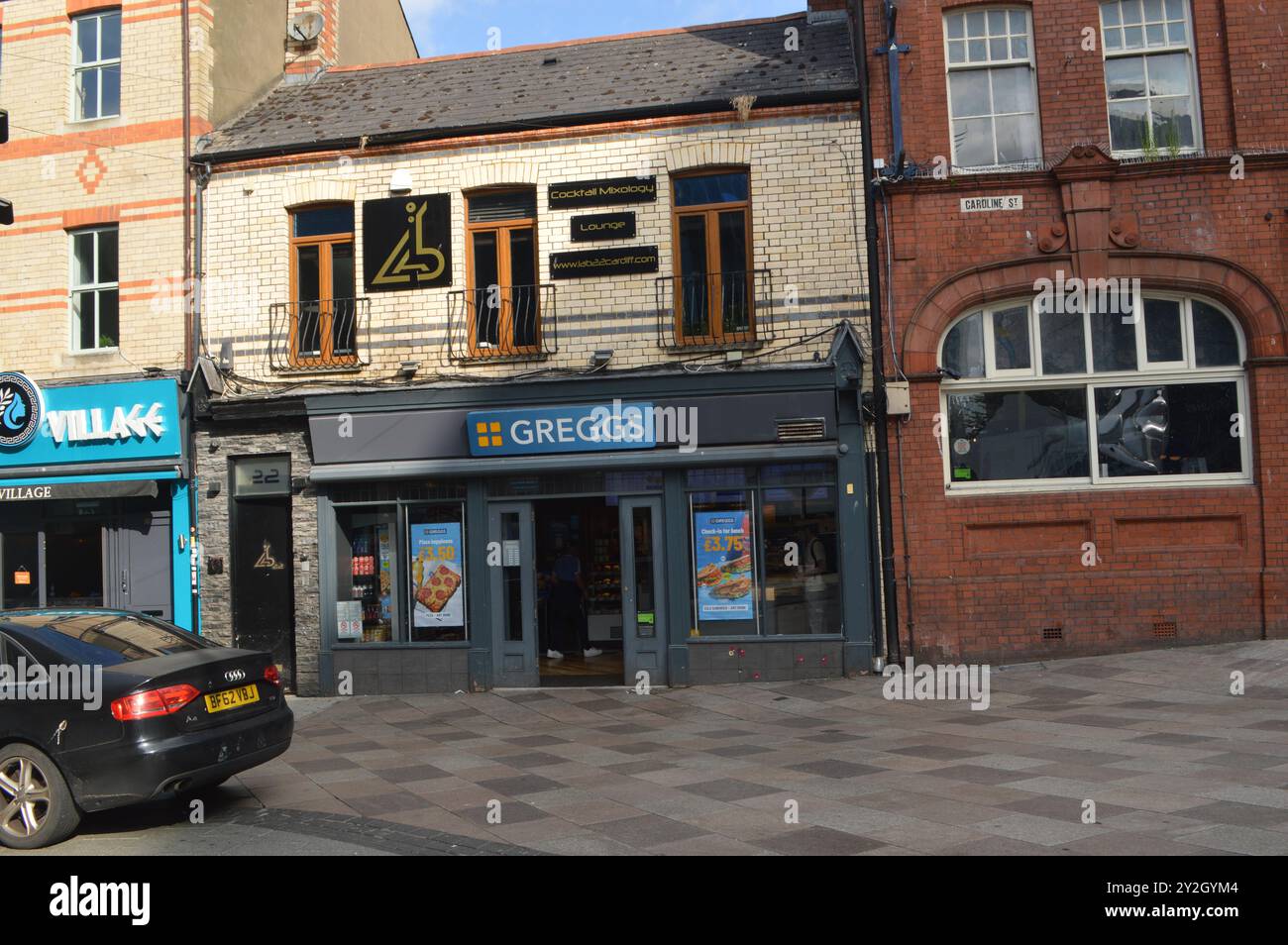 Greggs Bakery und Lab 22 Cocktailbar darüber in der Caroline Street. Cardiff, Wales, Vereinigtes Königreich. Juli 2024. Stockfoto