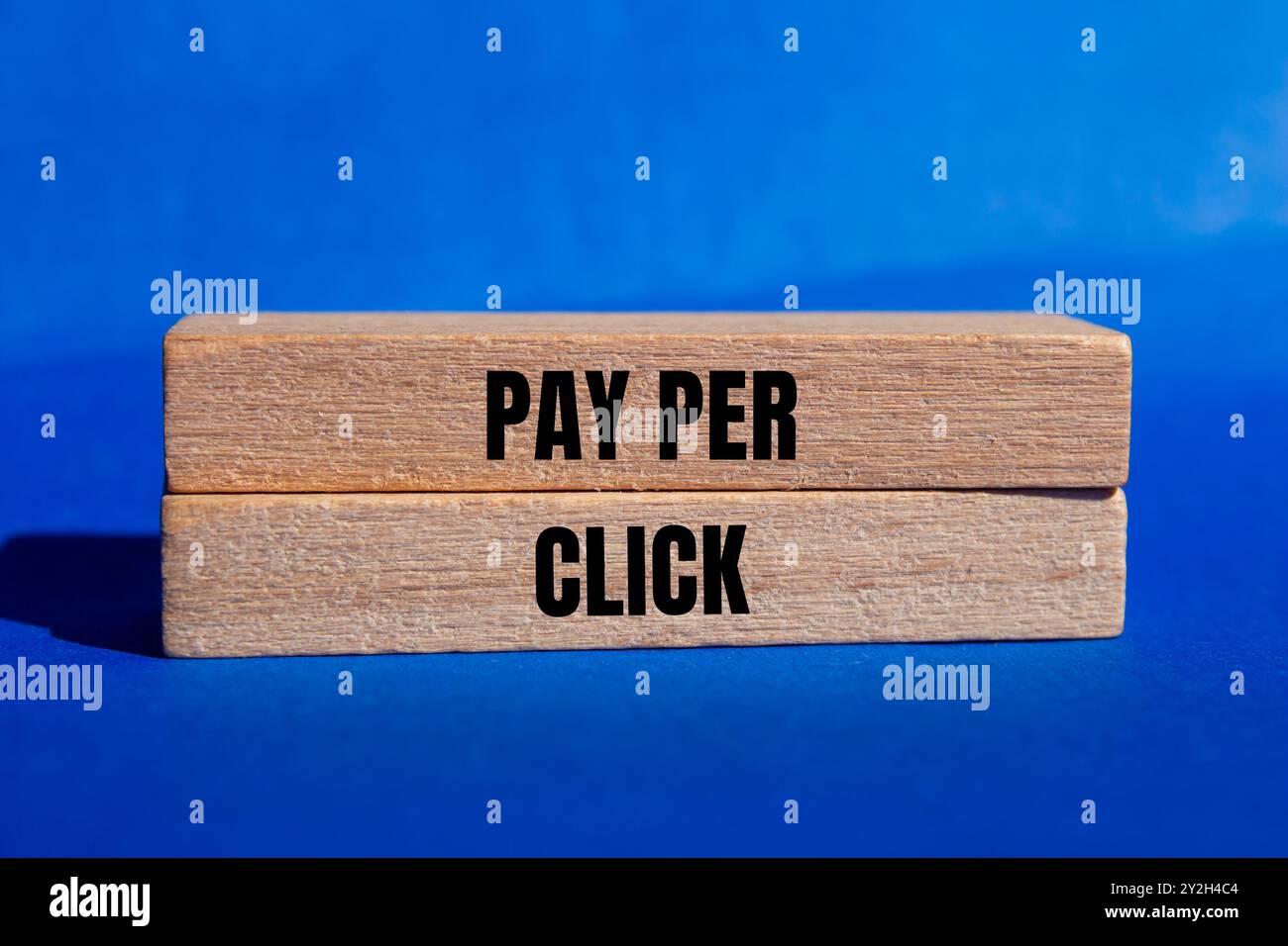 Pay-per-Click-Nachricht auf Holzblöcken mit blauem Hintergrund. Konzeptionelles Pay-per-Click-Symbol. Kopierbereich. Stockfoto