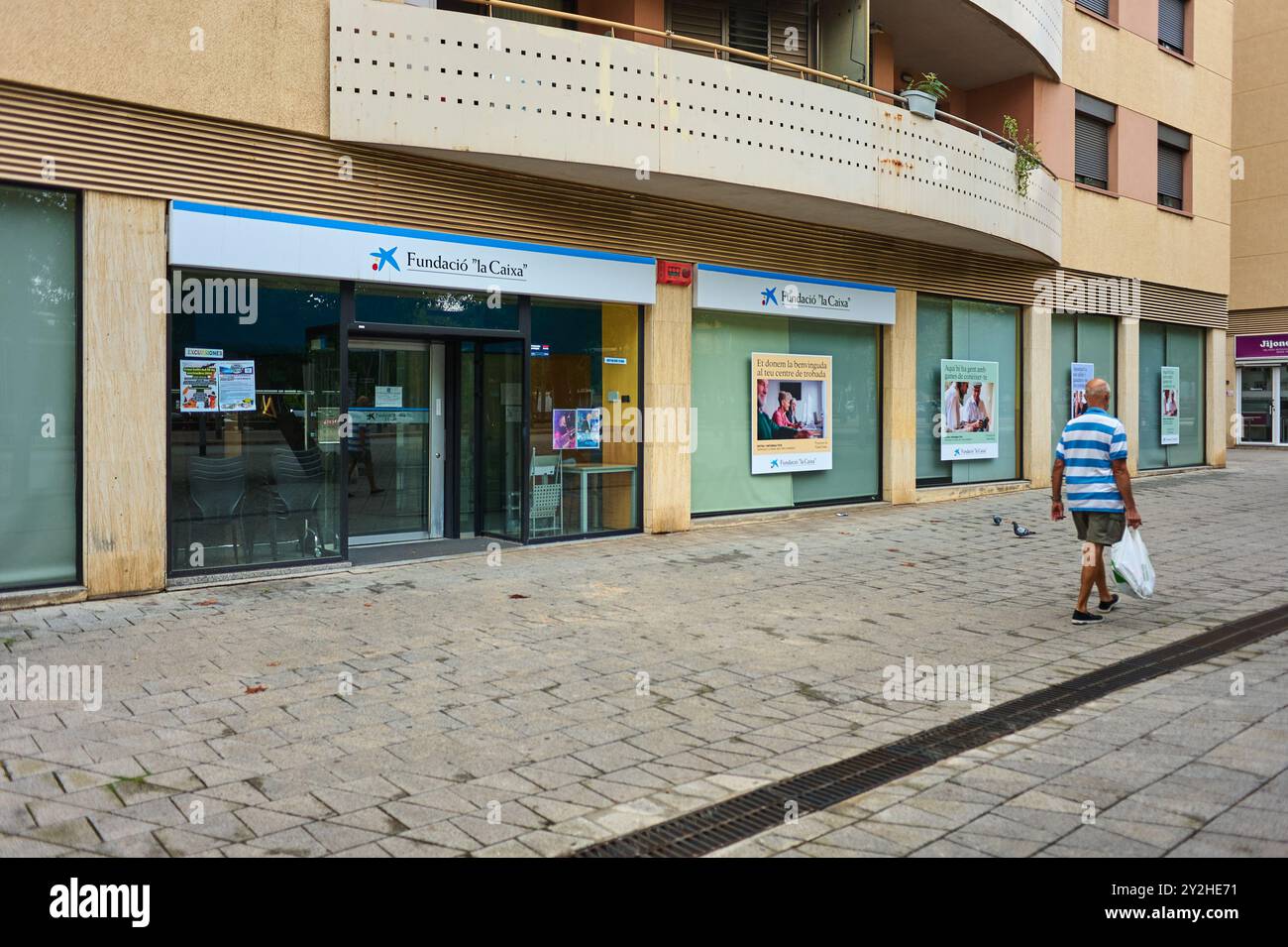 Viladecans, Barcelona-September 10.2024: Vorderansicht des Eingangs zur Fundacion la Caixa an einem bewölkten Tag mit Passanten und sichtbaren Schildern. Stockfoto