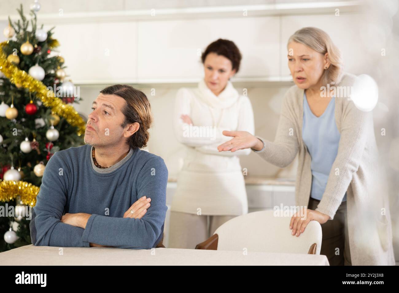 Ältere Mutter und Frau während des Familienstreits beschuldigen erwachsenen Mann am Heiligabend Stockfoto