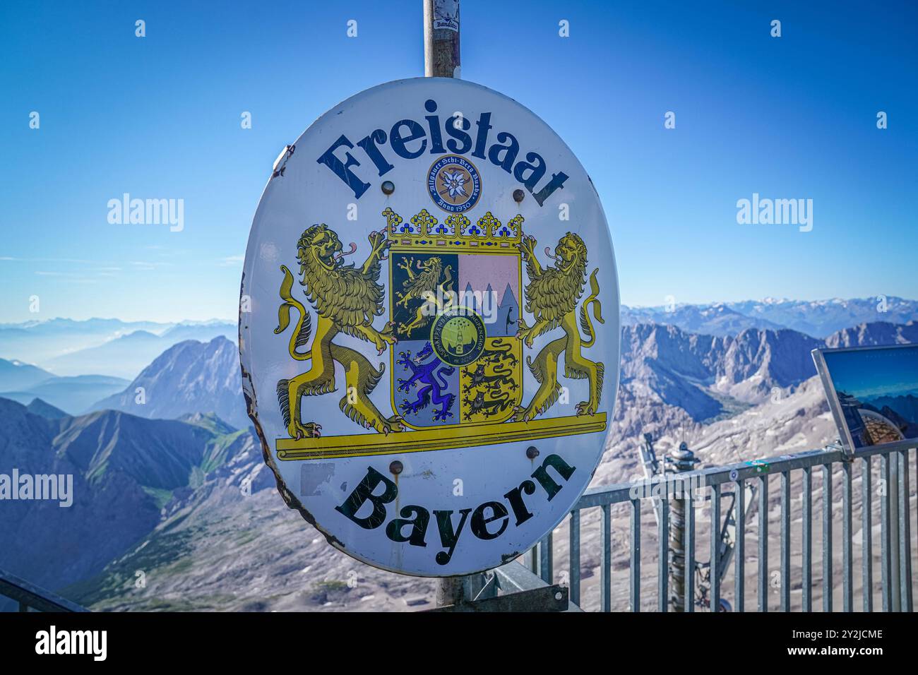 Freistaat Bayern, Bayern-Wappen, Grenzschild, Alpenkulisse, Zugspitze, höchster Punkt Deutschlands, bayerische Alpen, Berglandschaft, Staatswappen, Löwen, bayerische Tradition, Natur, atemberaubende Aussicht, Gebirgsregion, Grenze Bayern, Tourismus, Outdoor-Aktivität, Bergsteigen, Alpenpanorama, markanter Punkt, historische Bedeutung, bayerische Kultur, symbolischer Ort, Alpenregion, bayerische Identität. *** Freistaat Bayern, Bayerisches Wappen, Grenzschild, Alpenlandschaft, Zugspitze, höchster Punkt Deutschlands, Bayerische Alpen, Berglandschaft, Staatswappen, Löwen, bayerischer t Stockfoto