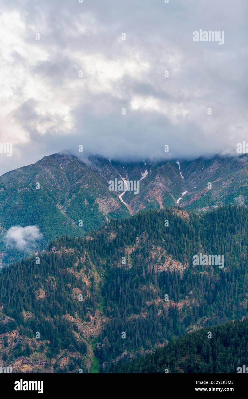 Monsunwolken bedecken die Berge des Himalaya, wie sie von Sangla, Himachal Pradesh, Indien, aus sichtbar sind. Stockfoto
