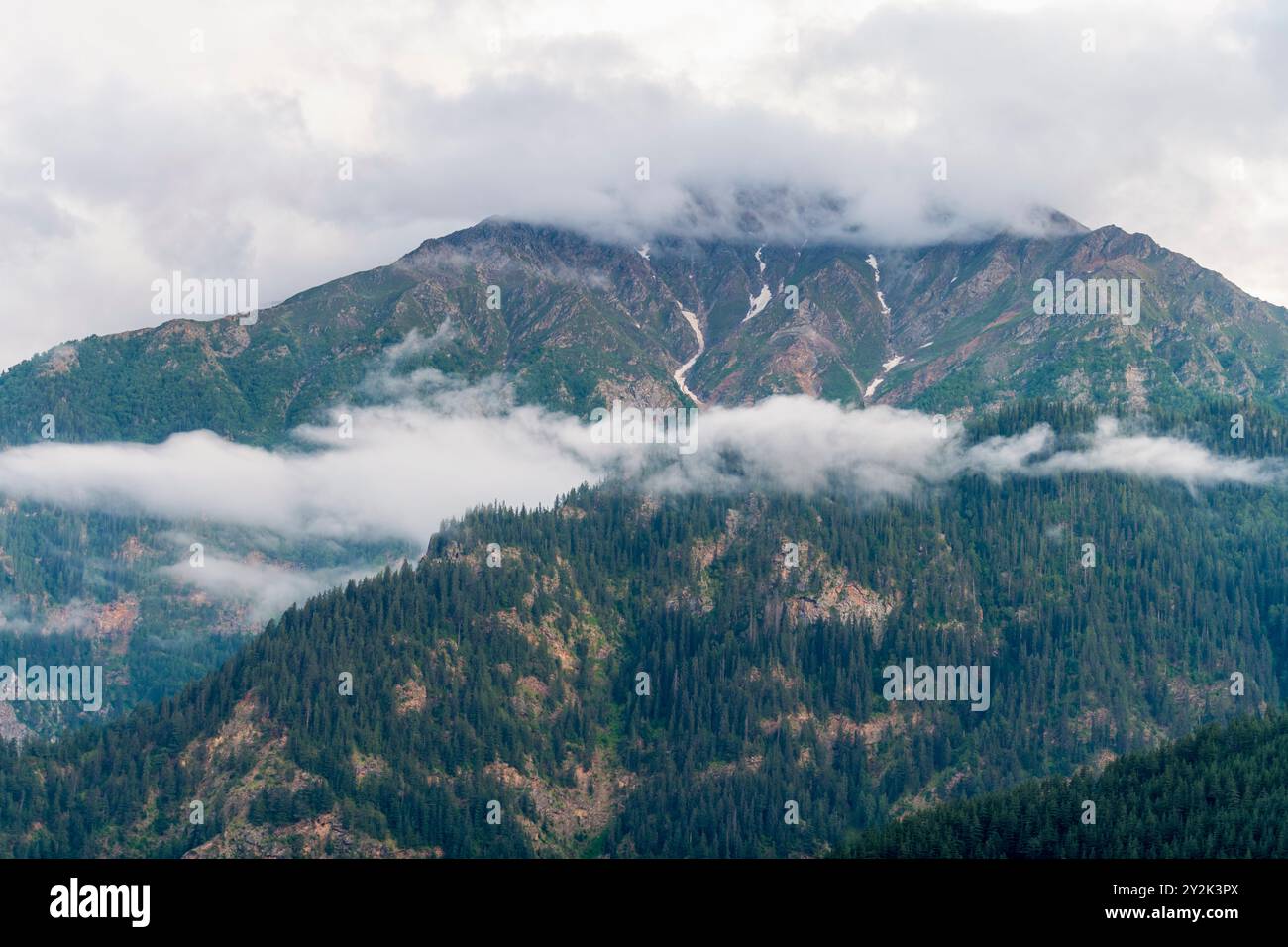 Monsunwolken bedecken die Berge des Himalaya, wie sie von Sangla, Himachal Pradesh, Indien, aus sichtbar sind. Stockfoto