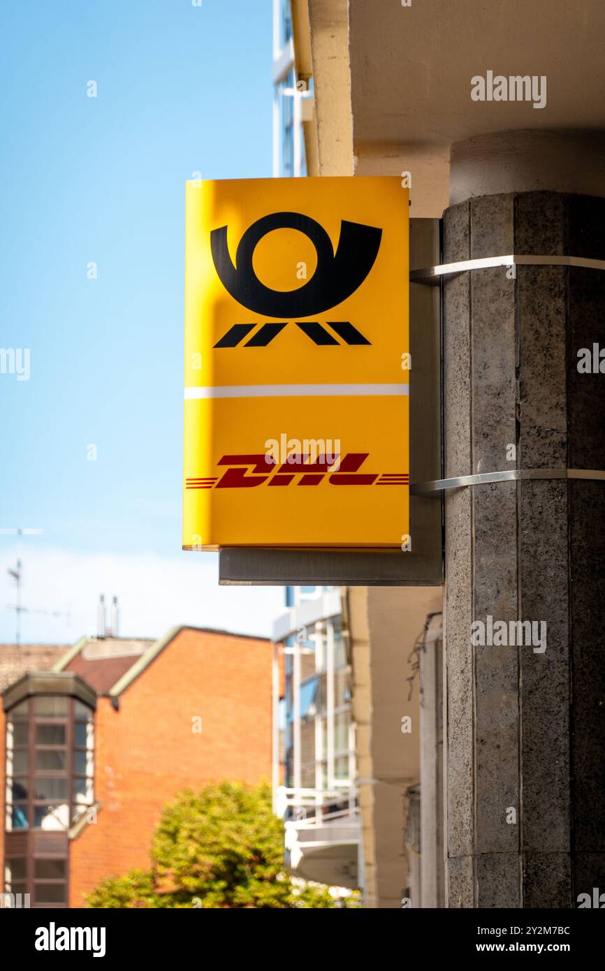 Koblenz, Deutschland - 7. September 2024: Ein hellgelbes Schild mit dem DHL-Logo ist an einem Gebäude angebracht. Der klare blaue Himmel sorgt für eine fröhliche Ba Stockfoto