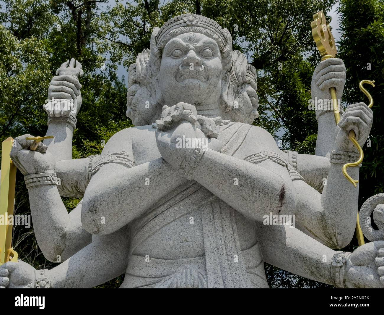 Ein Blick aus der Nähe auf eine mehrarmige Gottheit-Statue im Ishiteji-Tempel in Matsuyama, Japan, die komplizierte Handwerkskunst und religiöse Symbolik zeigt. Stockfoto