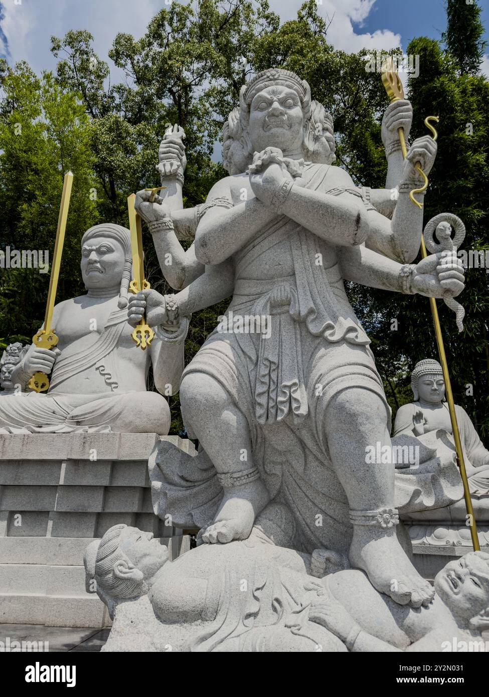 Eine wilde, mehrarmige Gottheit-Statue steht auf einer zertrampelten Figur im Ishiteji-Tempel in Matsuyama, Japan und symbolisiert Macht und Sieg über das Böse. Stockfoto