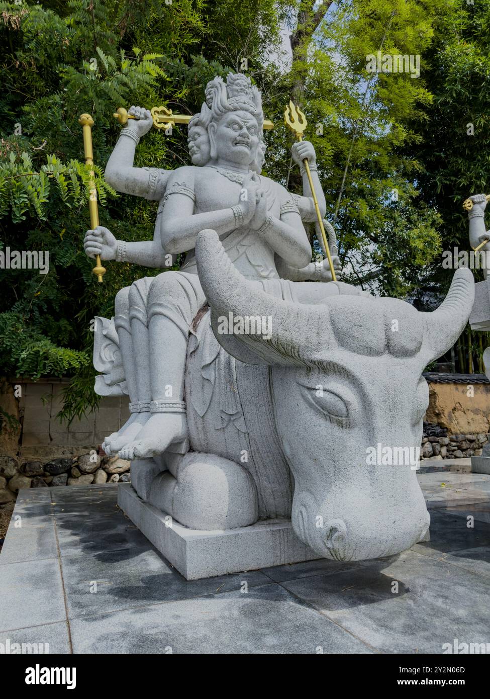 Eine mehrarmige Gottheit-Statue auf einem Stier im Ishiteji-Tempel in Matsuyama, Japan, repräsentiert Stärke und göttliche Macht in einer heiligen Umgebung Stockfoto