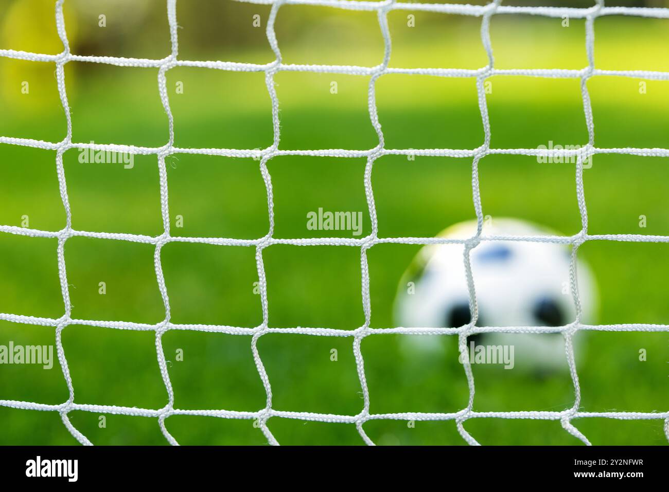 Fußball auf dem Rasenfeld hinter dem Tornetz Stockfoto