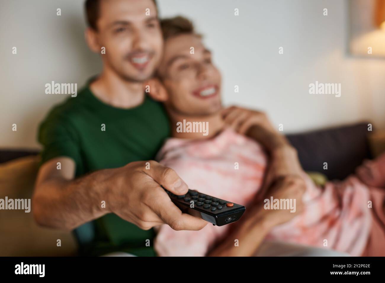 Ein liebevolles Paar genießt eine entspannte Nacht zu Hause und kuschelt auf der Couch. Stockfoto