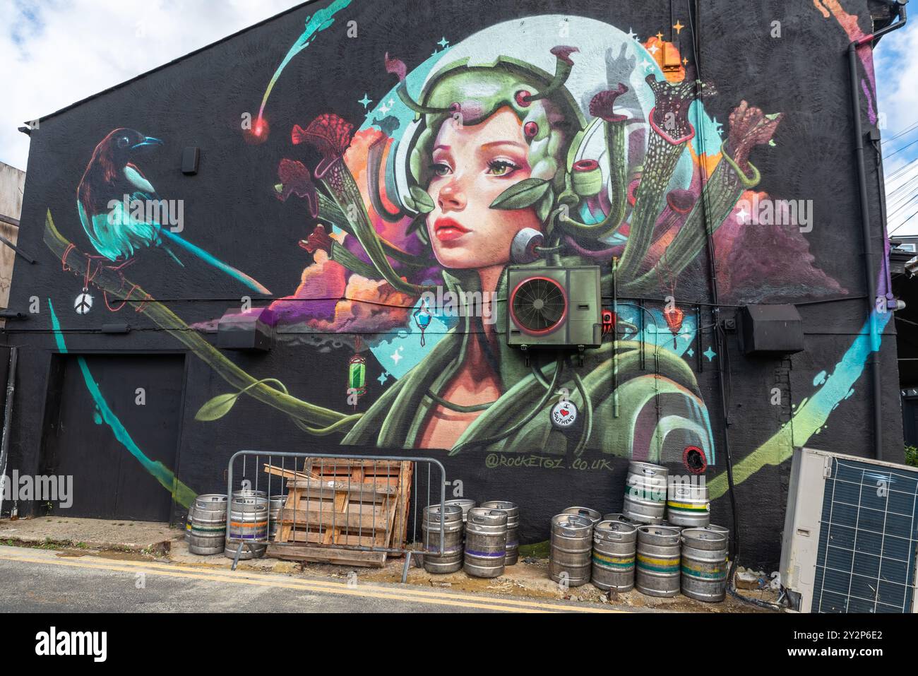 Southend City Jam Graffiti-Kunstveranstaltung in Southend on Sea, Essex, Großbritannien. Großes Wandgemälde an der Seite des Bar-Restaurants, mit leeren Bierfässern Stockfoto