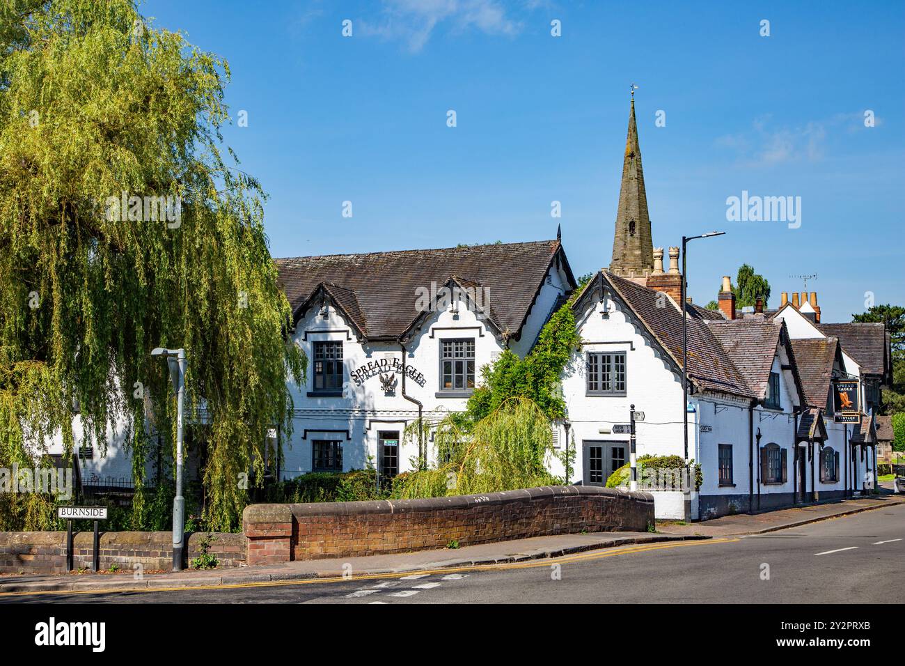 Der Spread Eagle Pub und der Turm der St. Mary's Church am Ufer des Flusses Dove im idyllischen Staffordshire-Dorf Rolleston on Dove Stockfoto