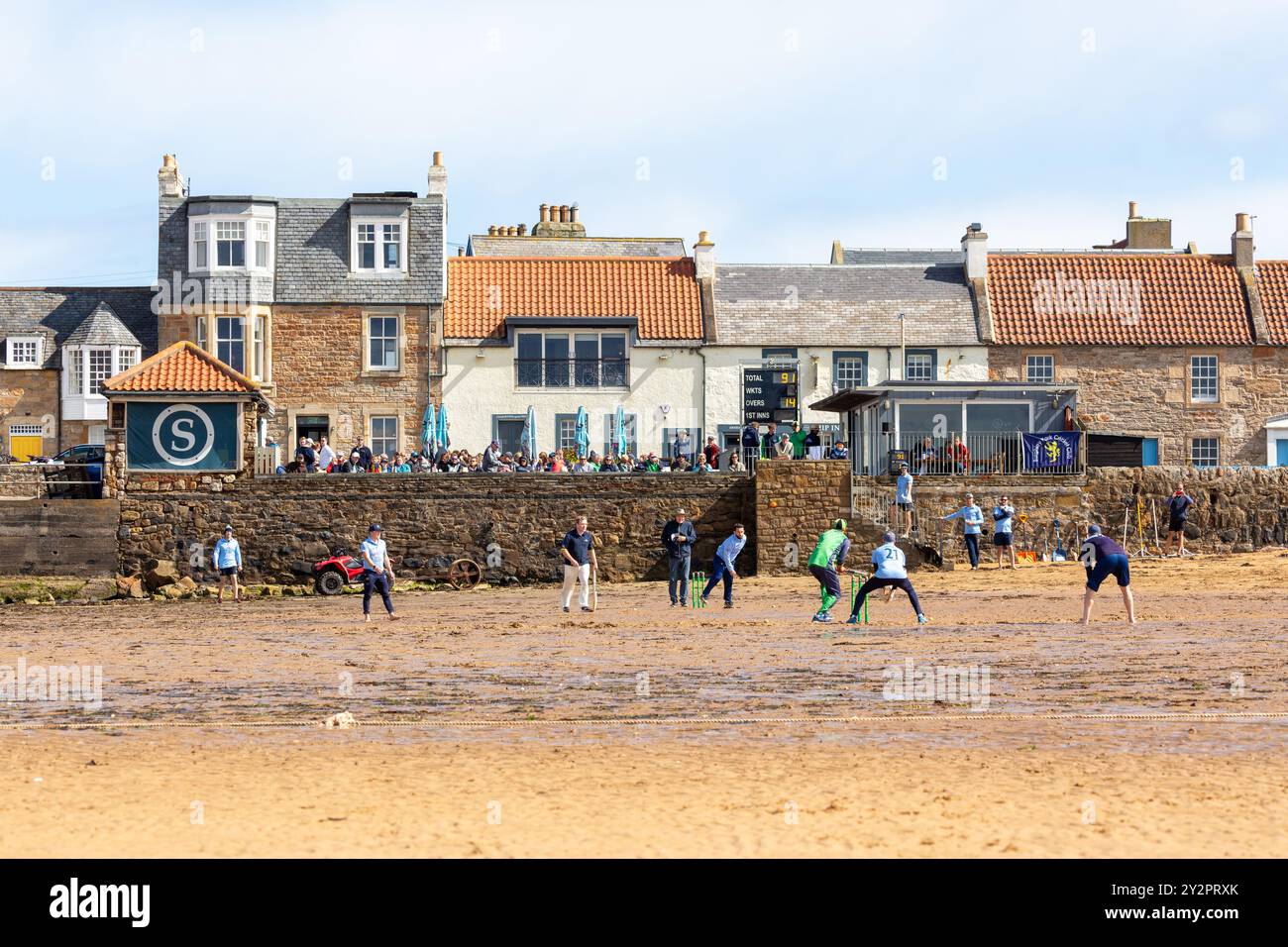 Leute spielen Cricket am Strand vor dem Ship Inn, Elie, Fife, Schottland Stockfoto