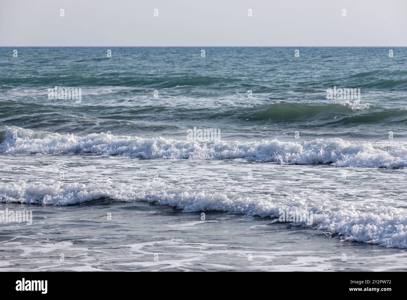 Küstenmeerwasser mit Wellen und Schaum, abstraktes natürliches Hintergrundfoto Stockfoto