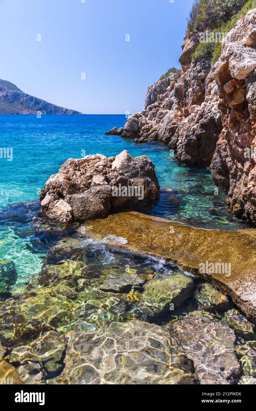 Blick auf die Küste von Kalkan, Türkei. TAS Ocak Plaji Sommerlandschaft, vertikales Foto mit der felsigen Küste des Mittelmeers an einem sonnigen Sommertag Stockfoto