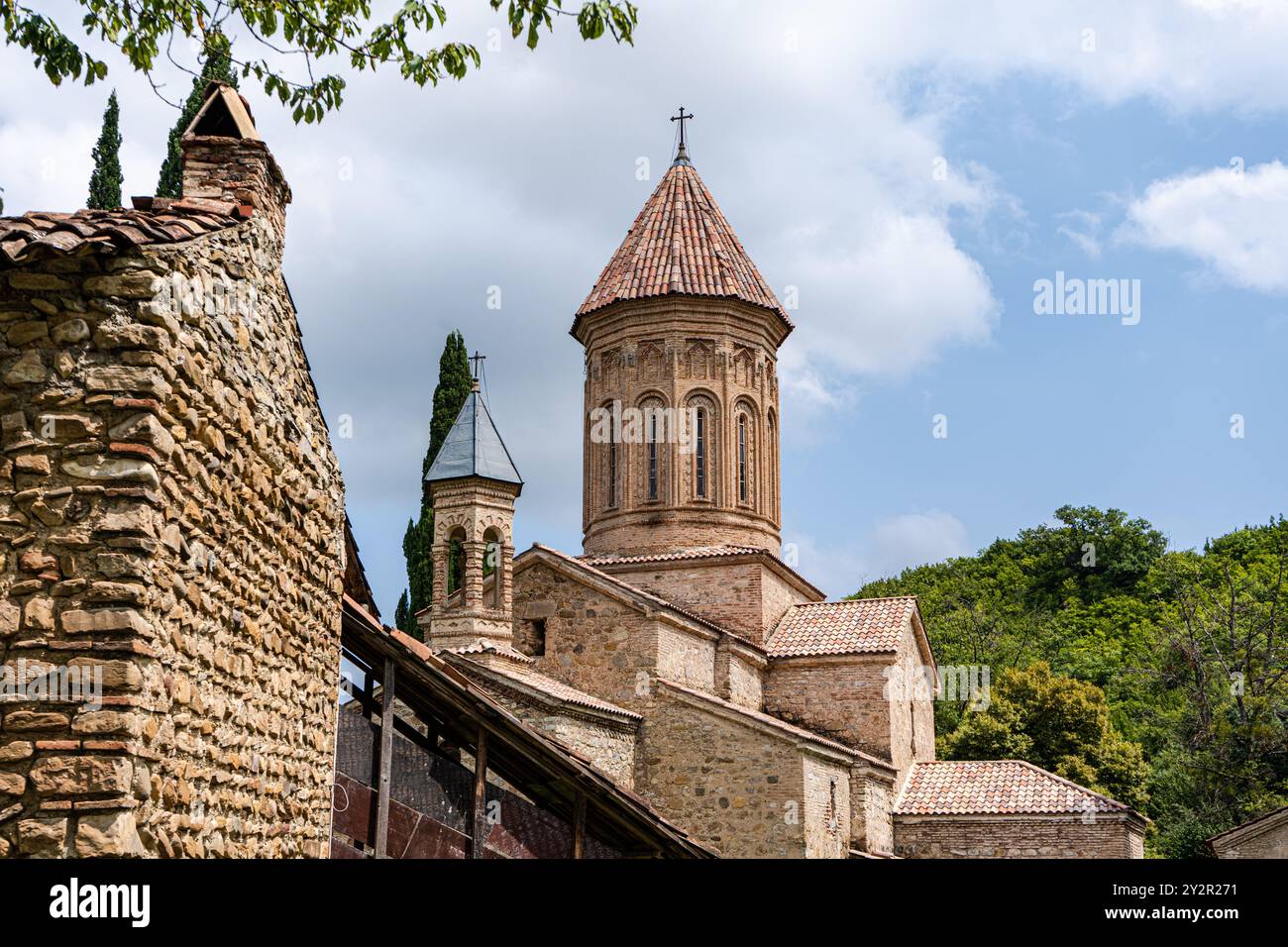 Die historischen Ruinen der Ikalto Academy in Georgia, mit der berühmten rot gekachelten Kuppel und alten Steinmauern umgeben von üppigem Grün unter einer Wolke Stockfoto