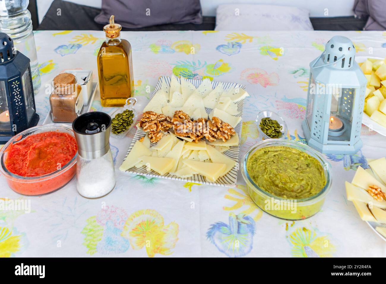 Eine Auswahl gesunder Lebensmittel für die Teilnehmer an einem Retreat, mit Käsescheiben, Walnüssen, Guacamole, Wassermelone, und eine Tomatensoße. Stockfoto